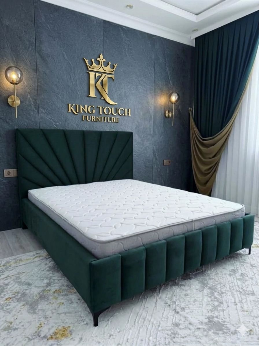 A luxury emerald green velvet Sunburst Headboard Bed by King Touch Furniture, featuring a fan-shaped tufted headboard and a matching vertical channel footboard, styled against a dark stone-textured feature wall with gold accents.