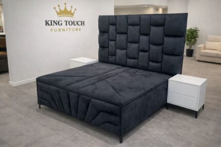 A luxurious black Compound Bed by King Touch Furniture featuring a high-profile, multi-block tufted headboard and a matching upholstered base with modern geometric stitched detailing, shown in a clean showroom setting.